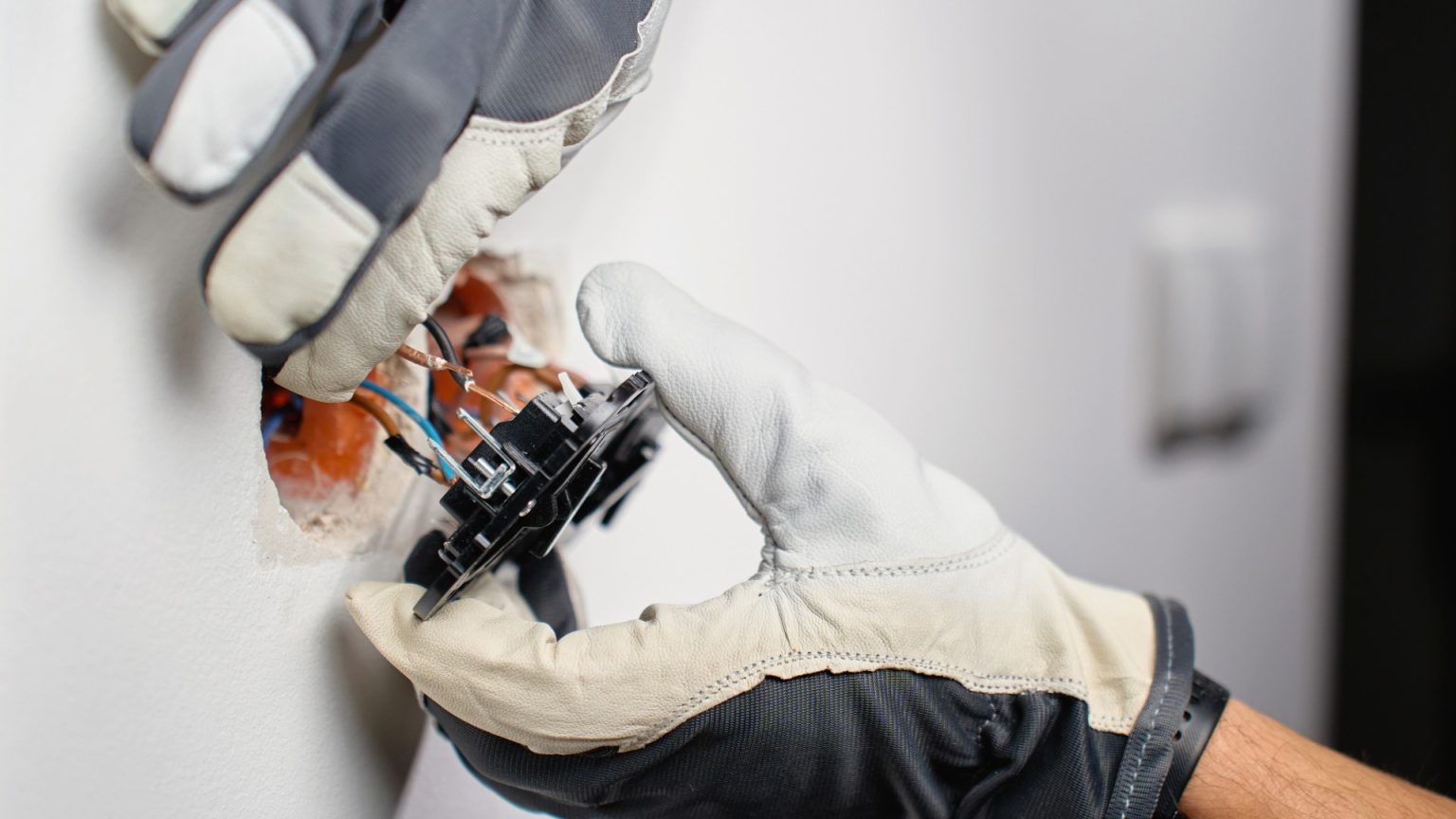 Ein Elektrostecker wird in der Wand angeschlossen.